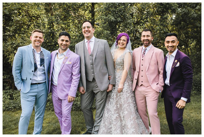 Colorful wedding party attire with mismatched groom and groomsmen suits; lavender suit, soft blue suit, pink suit, and purple suit