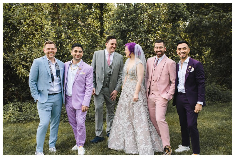 Mismatched bridal party attire; colorful groom and groomsmen attire complete with blue suit, lavender suit, pink suit, and purple suit