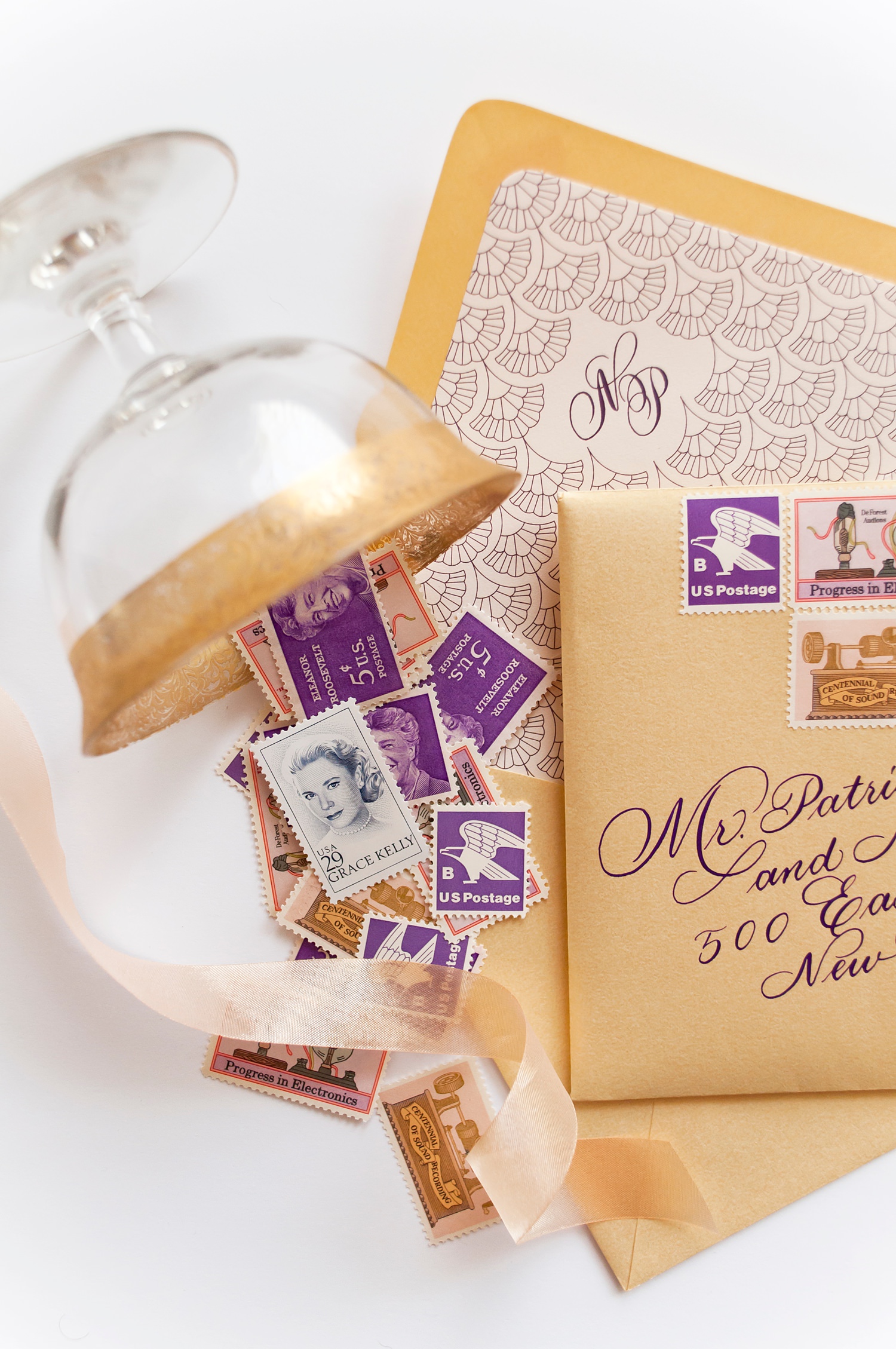 Gatsby themed wedding invites in blush pink, purple, and gold with letter press and laser cut details.