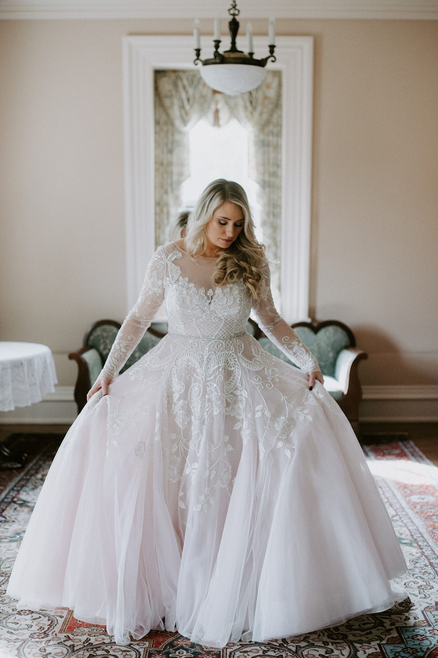 Gorgeous bride in long sleeve, blush wedding gown at The Webb Barn