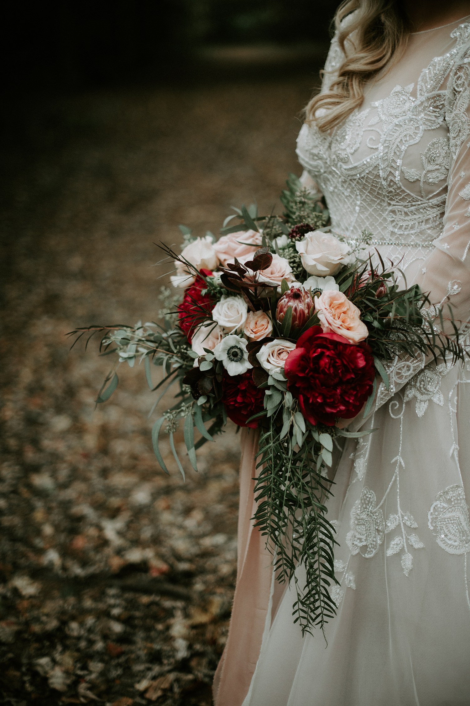 Rustic and luxurious bridal bouquet in marsala, red, blush, and green at The Webb Barn wedding